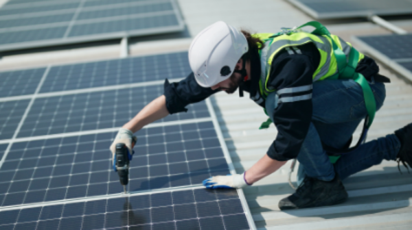 Techniker installiert Solarmodule auf einem Dach